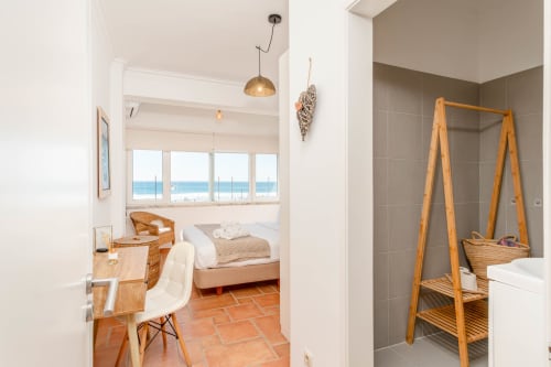Modern oceanview bedroom and bathroom at Republica do Sul, Charneca da Caparica, with wooden decor and sea views