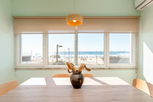 Bright dining area with ocean and beach views at Republica do Sul apartment in Aroeira, Portugal