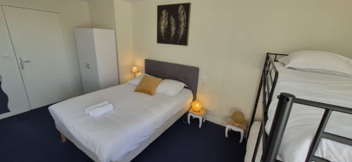 Chambre familiale à l'hôtel Aux Genêts d'Or à Trévé avec deux lits, literie blanche et mobilier moderne