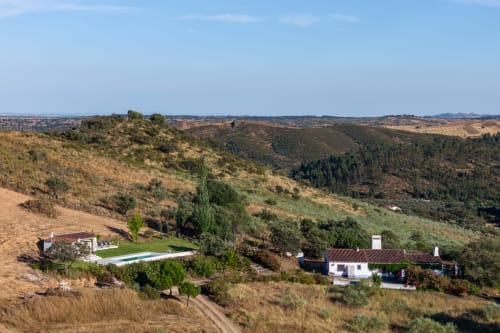 Vista aérea da villa Vale Clara no Alentejo com piscina, rodeada por colinas ondulantes e florestas perto de Alandroal