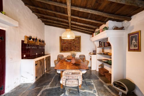 Sala de jantar rústica com vigas de madeira, piso de pedra e cadeiras tecidas na quinta Vale Clara em Alandroal, Portugal