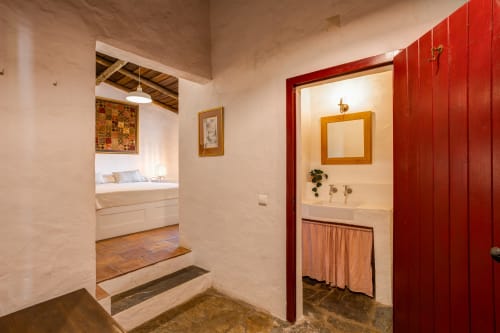 Entrada do corredor da villa Vale Clara em Alandroal mostrando portas de quarto e casa de banho com encanto rústico português