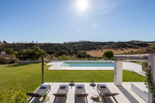 Villa Vale Clara em Alandroal com piscina, espreguiçadeiras, jardim bem cuidado e vistas do Alentejo sob céu limpo