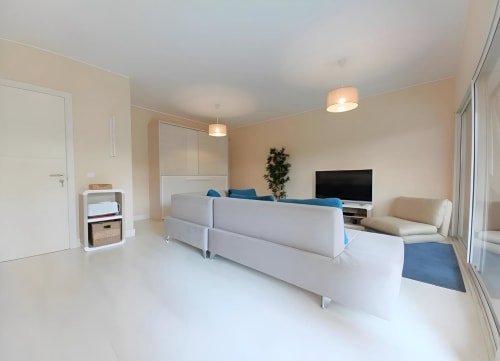 Moderna sala de estar do apartamento no Sweet Home Litoral Mar, Portimão com sofá cinza contemporâneo, TV e varanda com vista para o mar