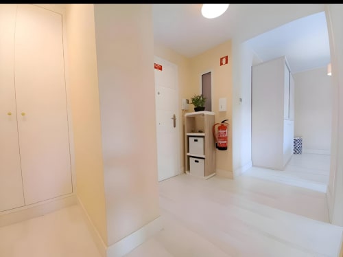 Corredor de apartamento moderno no Sweet Home Litoral Mar em Portimão com portas brancas, armazenamento e extintor
