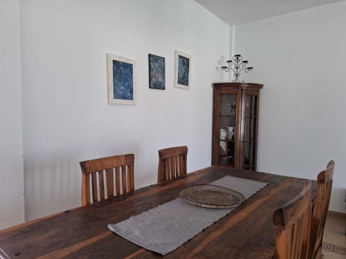 Dining room in Villa 8 at Villas del Mar with wooden table, chairs, and glass cabinet in Puerto Calero