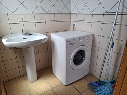 Clean bathroom in Villa 8 at Villas del Mar, Puerto Calero, featuring pedestal sink and washing machine