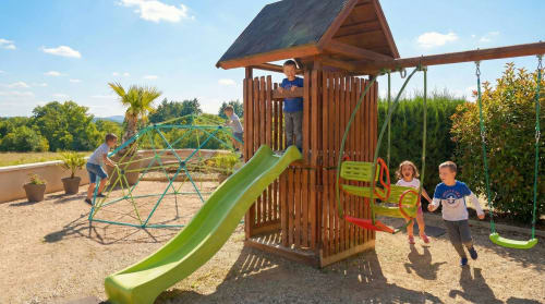 Enfants jouant dans la cour de récréation extérieure du Clos Des Anges, un gîte familial à Bagnols, France
