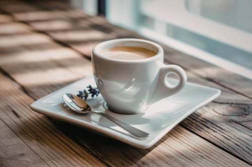 Tazza di espresso con piattino e cucchiaio presso Alla Basilica Rooms, San Giovanni Italia