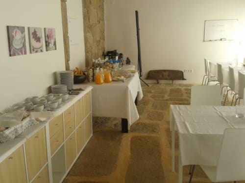 Sala de pequeno-almoço da Quinta de Anterronde em Arouca com buffet, mesas e vigas de madeira rústica