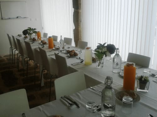 Elegante sala de jantar na Quinta de Anterronde com mesa posta, cadeiras, plantas e bebidas em Arouca, Portugal