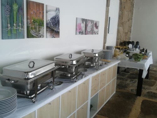 Buffet de catering na Quinta de Anterronde com travessas térmicas, louça e decoração botânica em Arouca