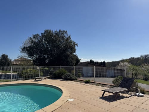 Piscine turquoise avec transats, terrasse et jardin clos au Gîte du Mercadal, Ariège, France