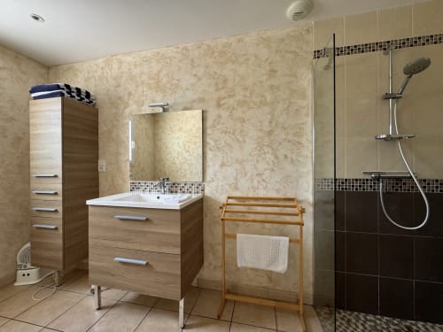 Salle de bain moderne du Gîte du Mercadal avec vasque en bois, douche italienne et sèche-serviettes chauffant à Les Pujols