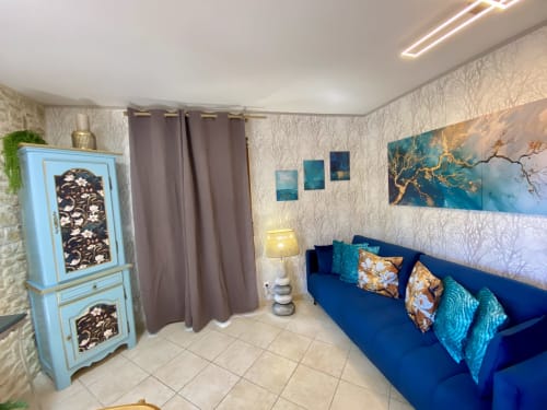 Chambre cosy avec canapé bleu, coussins turquoise, œuvres d'art et mobilier élégant à Ô Clair De Lune à Sarlat
