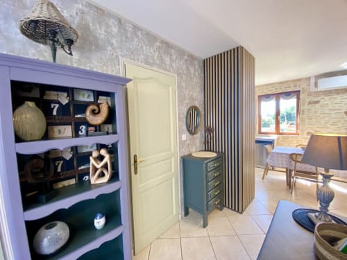 Chambre spacieuse à Ô Clair De Lune à Sarlat avec meuble vitré bleu, porte crème, cloison rayée et piscine