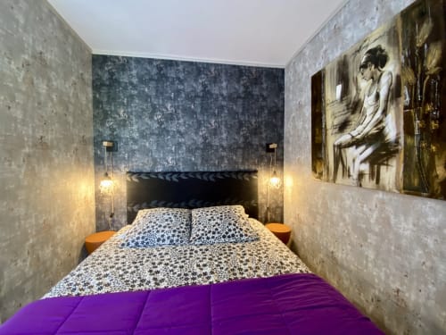 Chambre moderne du gîte Le Petit Prince à Sarlat, murs texturés, tête de lit foncée, literie patterned, plaid violet