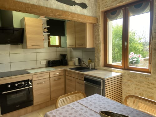 Cuisine du gîte Le Petit Prince à Sarlat avec mobilier bois, équipements modernes et vues sur le jardin