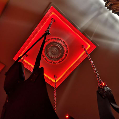 Luminaire de plafond néon rouge au design circulaire orné dans la salle The Suspended Moment à LA MAISON DEFENDUE, Tessy-Bocage