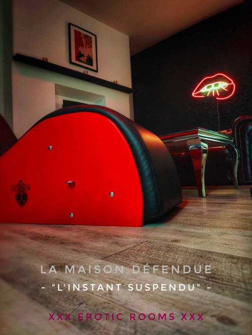 Mobilier de salon suspendu rouge moderne dans l'appartement 'Instant Suspendu' de LA MAISON DEFENDUE, avec enseigne néon lèvres et parquet