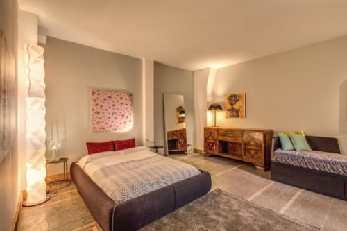 Camera da letto moderna nel The Smart Loft di Roma con due letti, cassettone in legno e illuminazione contemporanea