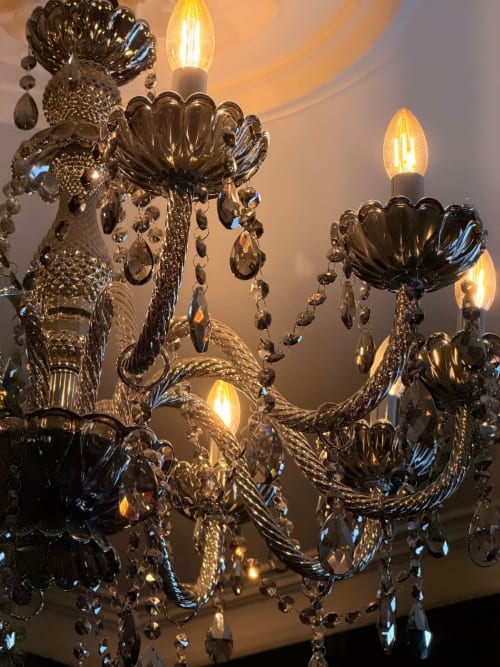 Élégant lustre en cristal noir avec ampoules style chandelles dans l'appartement La Cage Dorée à LA MAISON DEFENDUE,