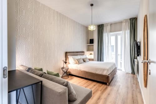 Camera da letto moderna nell'appartamento The Cloud di Downtown Srl Roma con letto queen size, divano, porte-finestre, pavimenti in legno e decori geometrici