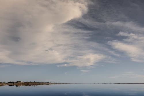 Serene wetlands landscape near Le Prieuré Notre-Dame in Montfrin, France with calm water reflection