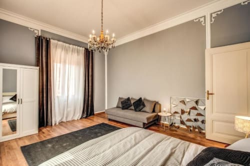 L'elegante appartamento retrò a Roma dispone di una spaziosa camera da letto con pavimenti in legno, lampadario di classe e divano letto