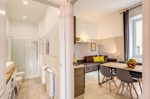 Moderno appartamento a Cinque Terre: bagno e zona living con doccia, tavolo da pranzo, divano letto e attrezzature cucina