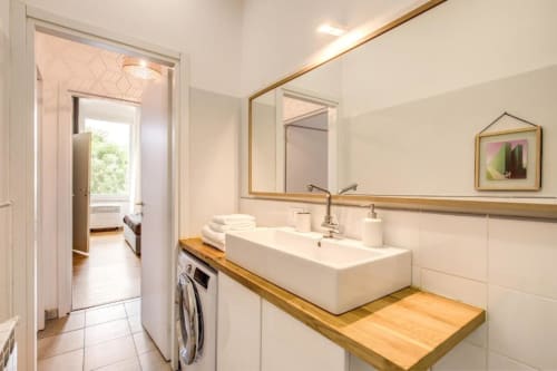 Bagno moderno in appartamento a Cinque Terre con doppio lavabo, mobile in legno e lavatrice