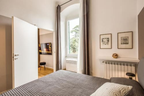 Camera moderna in appartamento a Cinque Terre con letto rigato, balcone con vista mare, radiatore e arredamento minimalista