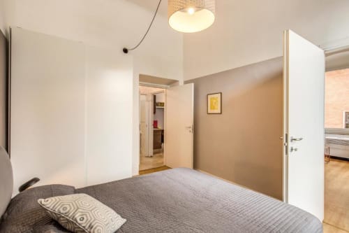 Camera da letto moderna in appartamento a Cinque Terre con letto matrimoniale, porta bianca, pareti beige e plafoniera