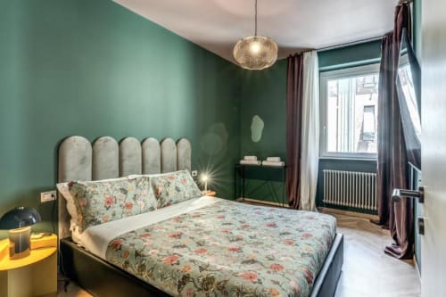 Camera da letto Cinque Terre Swing con pareti verde salvia, biancheria floreale, lampada a sospensione e finestra nell'appartamento Downtown Roma