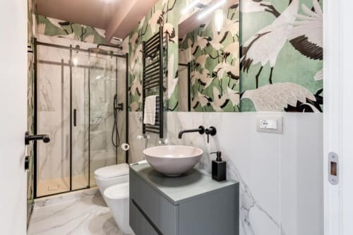 Bagno moderno nell'appartamento Cinque Terre Swing con carta da parati a motivi di uccelli verdi, lavabo rotondo bianco, doccia in marmo e nero
