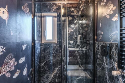 Lussuosa doccia in marmo nero con motivi decorativi di pesci nell'appartamento Cinque Terre Swing