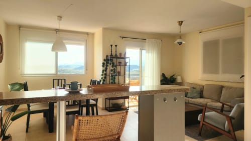 Sala de estar diáfana en apartamento de Águilas con vistas al mar, cocina moderna, comedor, asientos confortables y balcón