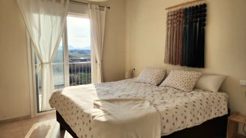Luminosa habitación con vistas al mar en BAKIT HOUSE en Águilas, España, con ropa de cama estampada y acceso a balcón