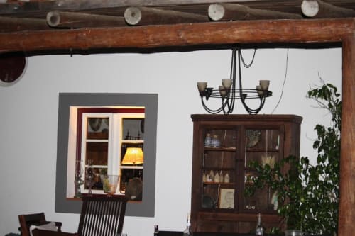 Rustic interior at Monte da Morena with wooden beams, display cabinets, chandelier, and climbing ivy in Serpa, Portugal