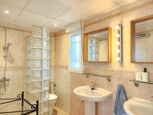 Baño moderno en Bakit House, Águilas con doble lavabo, mampara de cristal y espejo con iluminación con vistas al mar