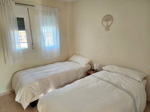 Habitación doble en BAKIT HOUSE Águilas con vistas al mar, ropa de cama blanca y luz natural desde las ventanas
