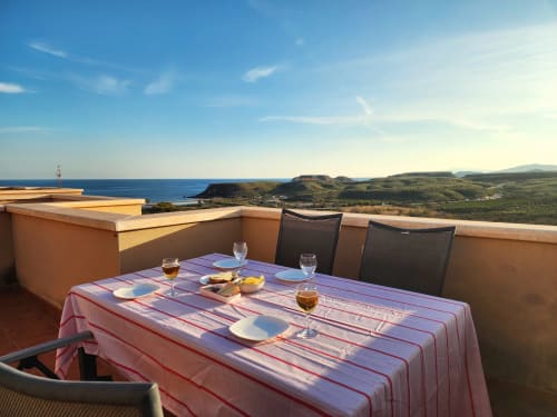 Comedor en terraza con vistas al Mar Mediterráneo y acantilados costeros en BAKIT HOUSE Águilas, España