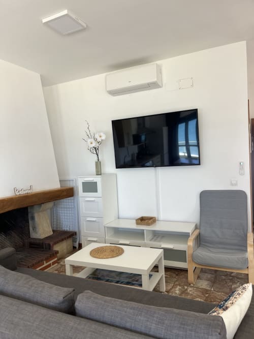 Moderno salón con vistas al mar, televisor de pantalla plana, chimenea y mobiliario confortable en Apartamentos A la Orilla del Mar,