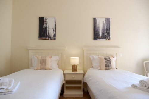 Twin beds with white linens in A Casa dos Príncipes apartment at Be SilverCoast hotel, Serra D'El Rei, Portugal