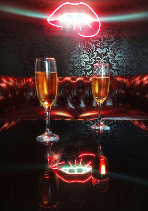 Enseigne néon lèvres au-dessus de verres de champagne au salon La Maison Defendue, Tessy-Bocage