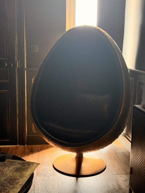 Black egg-shaped chair with pedestal base at La Maison Defendue hotel in Tessy-Bocage
