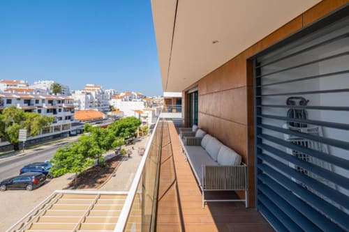 Varanda de apartamento de luxo em Atlantic Places Albufeira com vista para a cidade, mobiliário moderno e vista mar