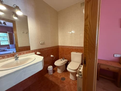 Baño del Hotel Restaurante Casa Manolo con lavamanos, bidé, inodoro y piso de baldosa terracota en Adra