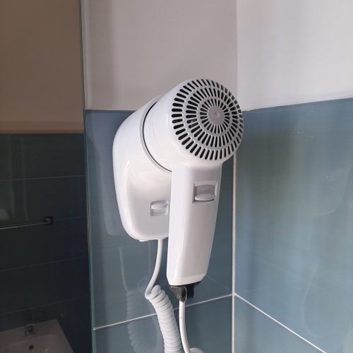 Asciugacapelli bianco a parete nel bagno della suite My Comfort Suite a Napoli, Italia
