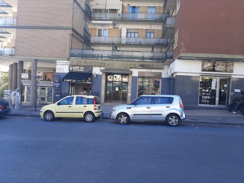 Veduta stradale del My Comfort Suite B&B a Napoli, Italia con auto parcheggiate e vetrine